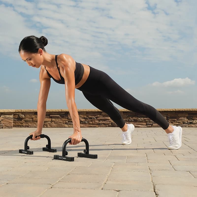 Woman using Sweet Sweat® push up bars.