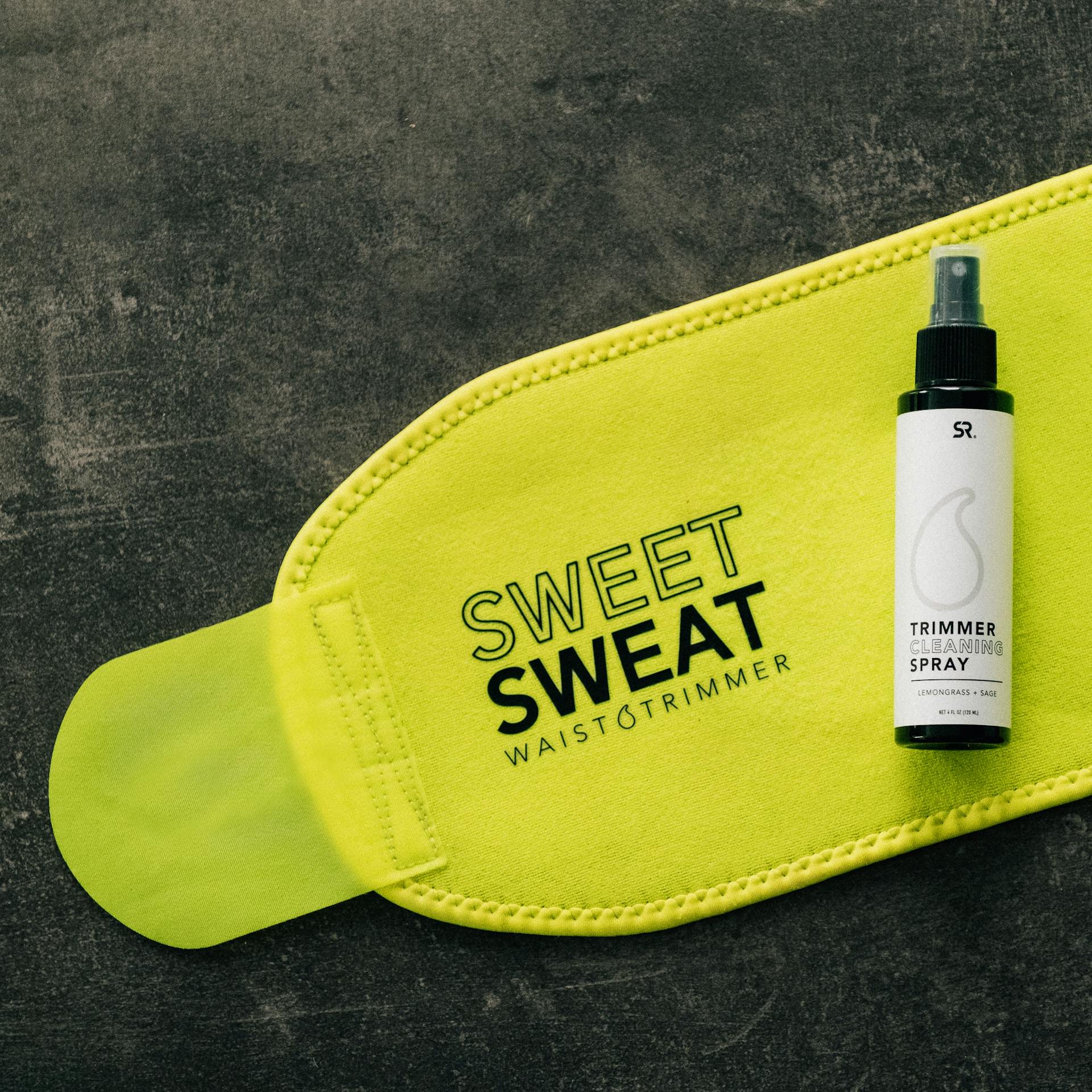 Sports Research® Cleaning Spray laying on top of a Sweet Sweat® Neon Series waist trimmer.